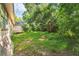 A backyard view of a house, showing a grassy area, some trees, and foliage at 1511 Center Ave, Holly Hill, FL 32117