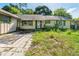 A charming single-story home featuring a traditional design, a paved walkway, and green accents at 1511 Center Ave, Holly Hill, FL 32117