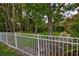 View of the white fence surrounding the backyard with ample mature trees and landscaping at 1679 Shadowmoss Cir, Lake Mary, FL 32746
