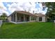 Exterior view of the home's backyard with a white fence and screened in patio at 1679 Shadowmoss Cir, Lake Mary, FL 32746