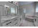 Bright bathroom featuring double sinks, marble countertops, and a glass-enclosed shower at 1679 Shadowmoss Cir, Lake Mary, FL 32746