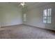 Spacious bedroom with a tray ceiling, plantation shutters, and plush neutral carpet at 1679 Shadowmoss Cir, Lake Mary, FL 32746