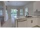 Kitchen boasts marble countertops, stainless steel dishwasher and view to outdoor patio through sliding glass door at 1679 Shadowmoss Cir, Lake Mary, FL 32746