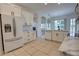 Well-lit kitchen with white cabinetry, tile floors, and a view into the living spaces at 1679 Shadowmoss Cir, Lake Mary, FL 32746