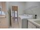 Functional laundry room includes a utility sink, shelving, and tile flooring at 1679 Shadowmoss Cir, Lake Mary, FL 32746