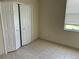 Bedroom with tile flooring, a window with blinds, and bi-fold closet doors at 2149 Mallard Creek Cir, Kissimmee, FL 34743