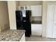Kitchen featuring a black refrigerator, granite countertops, and white cabinetry at 2149 Mallard Creek Cir, Kissimmee, FL 34743