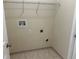 A functional laundry room with tile flooring, featuring utility connections and shelving for organized storage at 2149 Mallard Creek Cir, Kissimmee, FL 34743