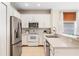 Bright kitchen features white cabinets, stainless steel appliances, and a tiled backsplash at 253 Clydesdale Cir, Sanford, FL 32773