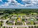 Expansive aerial view of a well-maintained home in a lush, green neighborhood with clear blue skies and scattered clouds at 2781 Sand Oak Loop, Apopka, FL 32712