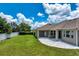 Well-maintained backyard showing covered patio, stone pavers and green lawn at 2781 Sand Oak Loop, Apopka, FL 32712