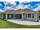 The backyard features a covered patio with stone pavers and lush green grass at 2781 Sand Oak Loop, Apopka, FL 32712