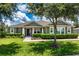 Charming single-story home featuring a well-manicured lawn, mature tree, and neutral-toned facade at 2781 Sand Oak Loop, Apopka, FL 32712