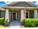 Inviting covered porch with white columns, manicured bushes, and black front door at 2781 Sand Oak Loop, Apopka, FL 32712