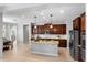Bright kitchen features a center island with granite countertops and dark wood cabinets at 2781 Sand Oak Loop, Apopka, FL 32712
