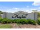 A welcoming entrance to the Mayhill community under a bright blue sky at 3984 Mayhill Loop, Eustis, FL 32736