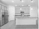 A bright kitchen features gray cabinets, granite countertops, stainless steel appliances, and a spacious center island at 3984 Mayhill Loop, Eustis, FL 32736