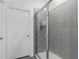 Modern tiled shower with a glass door and white door for privacy at 3984 Mayhill Loop, Eustis, FL 32736