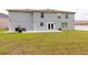 Home's rear exterior with covered patio and well-maintained yard provides space for relaxation and entertaining at 4064 Sunny Day Way, Kissimmee, FL 34744