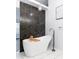 Bright bathroom featuring a soaking tub with a modern faucet and a stylish wall tile accent at 4064 Sunny Day Way, Kissimmee, FL 34744