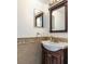 Bathroom sink with tile backsplash and dark wood cabinet and stylish mirror at 4064 Sunny Day Way, Kissimmee, FL 34744