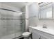 Bathroom featuring a glass shower with marble-look tile, a sink and toilet and a stylish mirror at 4064 Sunny Day Way, Kissimmee, FL 34744