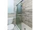 Bathroom featuring a glass shower with modern wood-look tile, and a toilet with a matching wood-look at 4064 Sunny Day Way, Kissimmee, FL 34744