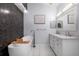 Bright bathroom featuring a soaking tub, a modern vanity with double sinks and stylish wall tile at 4064 Sunny Day Way, Kissimmee, FL 34744