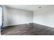A well lit bedroom with gray walls, dark wood-look flooring, and a large curtained window at 4064 Sunny Day Way, Kissimmee, FL 34744