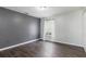 Bedroom featuring vinyl floors, gray accent wall, a window with curtains and a modern ceiling light at 4064 Sunny Day Way, Kissimmee, FL 34744