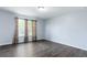 Bedroom featuring vinyl floors, blue walls, a window with curtains and a modern ceiling light at 4064 Sunny Day Way, Kissimmee, FL 34744