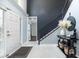 Elegant entryway with tile flooring, a staircase with black iron railings and white painted door at 4064 Sunny Day Way, Kissimmee, FL 34744