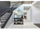 Elegant entryway with tile flooring, a staircase with black iron railings and a decorative console table at 4064 Sunny Day Way, Kissimmee, FL 34744