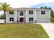 Charming two-story home with a palm tree, green lawn, and well manicured landscaping at 4064 Sunny Day Way, Kissimmee, FL 34744