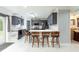 Spacious kitchen featuring an island with bar stool seating, gray cabinetry, and stainless steel appliances at 4064 Sunny Day Way, Kissimmee, FL 34744
