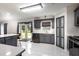 Bright kitchen with gray cabinetry, white countertops, stainless steel appliances and white tile flooring at 4064 Sunny Day Way, Kissimmee, FL 34744