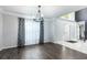Sunlit living room with wood floors, crown molding, and view of front entry and staircase at 4064 Sunny Day Way, Kissimmee, FL 34744
