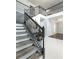 Elegant staircase with dark wooden steps and black ornate iron railings leading to the second story at 4064 Sunny Day Way, Kissimmee, FL 34744