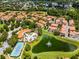 Stunning aerial view showcasing a community with a pool, tennis court, and a beautiful pond with a fountain at 4244 Messina Dr, Lake Mary, FL 32746