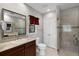 Bathroom featuring a vanity sink, toilet, and modern tiled glass shower with neutral earth tones at 4244 Messina Dr, Lake Mary, FL 32746