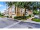 Exterior shot of townhomes with lush trees, two-car garages, and landscaped surroundings on a charming street at 4244 Messina Dr, Lake Mary, FL 32746