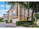 Exterior view of townhomes featuring lush trees, attached two-car garages, and well-maintained landscaping in a serene setting at 4244 Messina Dr, Lake Mary, FL 32746
