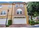 Townhome garages featuring two-car capacity, enhanced by a well-maintained facade, landscaping, and exterior lighting at 4244 Messina Dr, Lake Mary, FL 32746