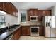 Kitchen with stainless steel appliances, dark wood cabinets, and tile flooring at 4244 Messina Dr, Lake Mary, FL 32746