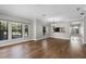 Open-concept living room with hardwood floors, large windows, and kitchen access at 4244 Messina Dr, Lake Mary, FL 32746