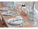 Artistically set dining table with plates, silverware, glassware, and neutral place settings at 4973 Windermere Ave, Kissimmee, FL 34746