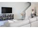 Bright living room with stairs, a sofa, and a large TV at 4973 Windermere Ave, Kissimmee, FL 34746