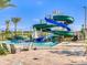 Community waterpark featuring a winding water slide, lounge chairs, umbrella, and splash pool on a sunny day at 4973 Windermere Ave, Kissimmee, FL 34746