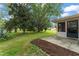Landscaped backyard featuring mature trees and an enclosed porch at 5237 Gateway Ave, Orlando, FL 32821