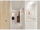 Hallway with tiled floors leading to a bathroom with white cabinets at 5237 Gateway Ave, Orlando, FL 32821